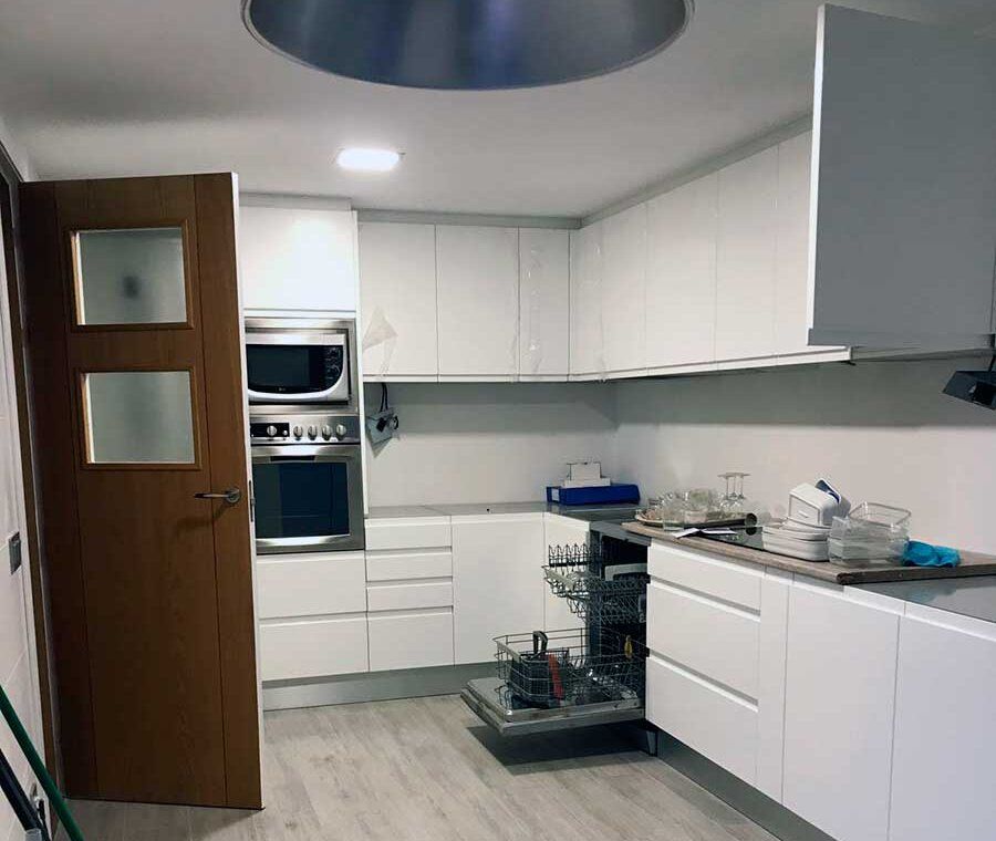Cocina blanca reformada por Reformas RMB en un piso de Madrid